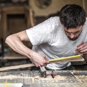 a man works on the machine with the wooden product manufacturing